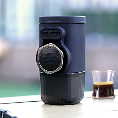 Espresso coffee maker with a glass of coffee on a blurred outdoor background
