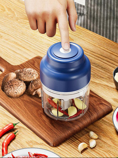 Handheld food chopper on a wooden cutting board with ingredients