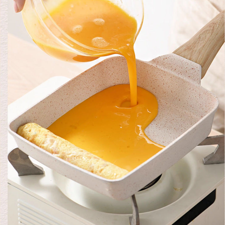 Pouring yellow liquid into a white rectangular dish with a wooden spatula.