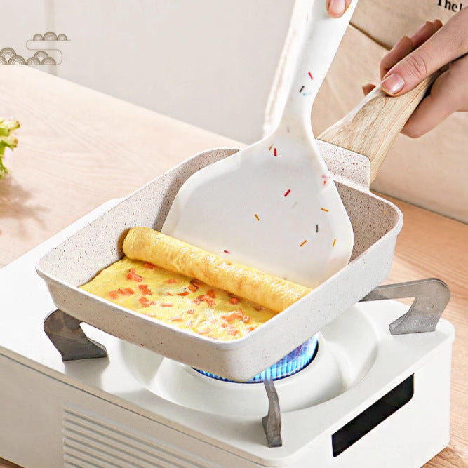 Omelette in a pan with a spatula on a stove