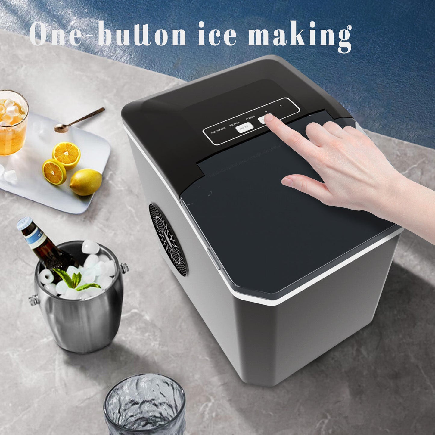 Ice maker with a hand pressing a button, surrounded by drinks and fruits on a table.