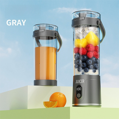 Gray portable juicer with fruits and juice on a light blue background