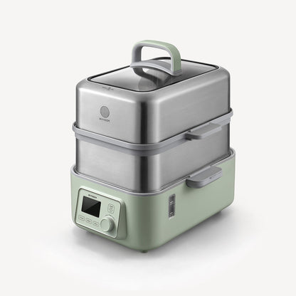 Green and silver food steamer on a white background